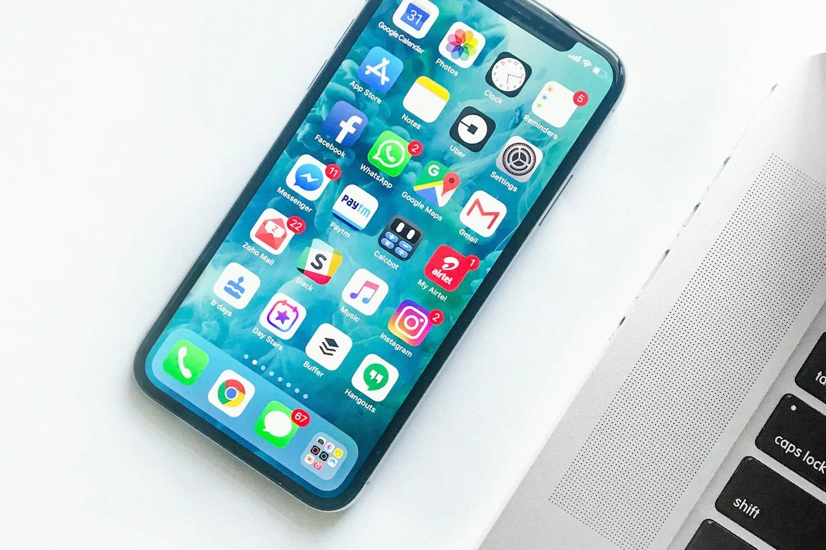 Smartphone beside a laptop on a white desk