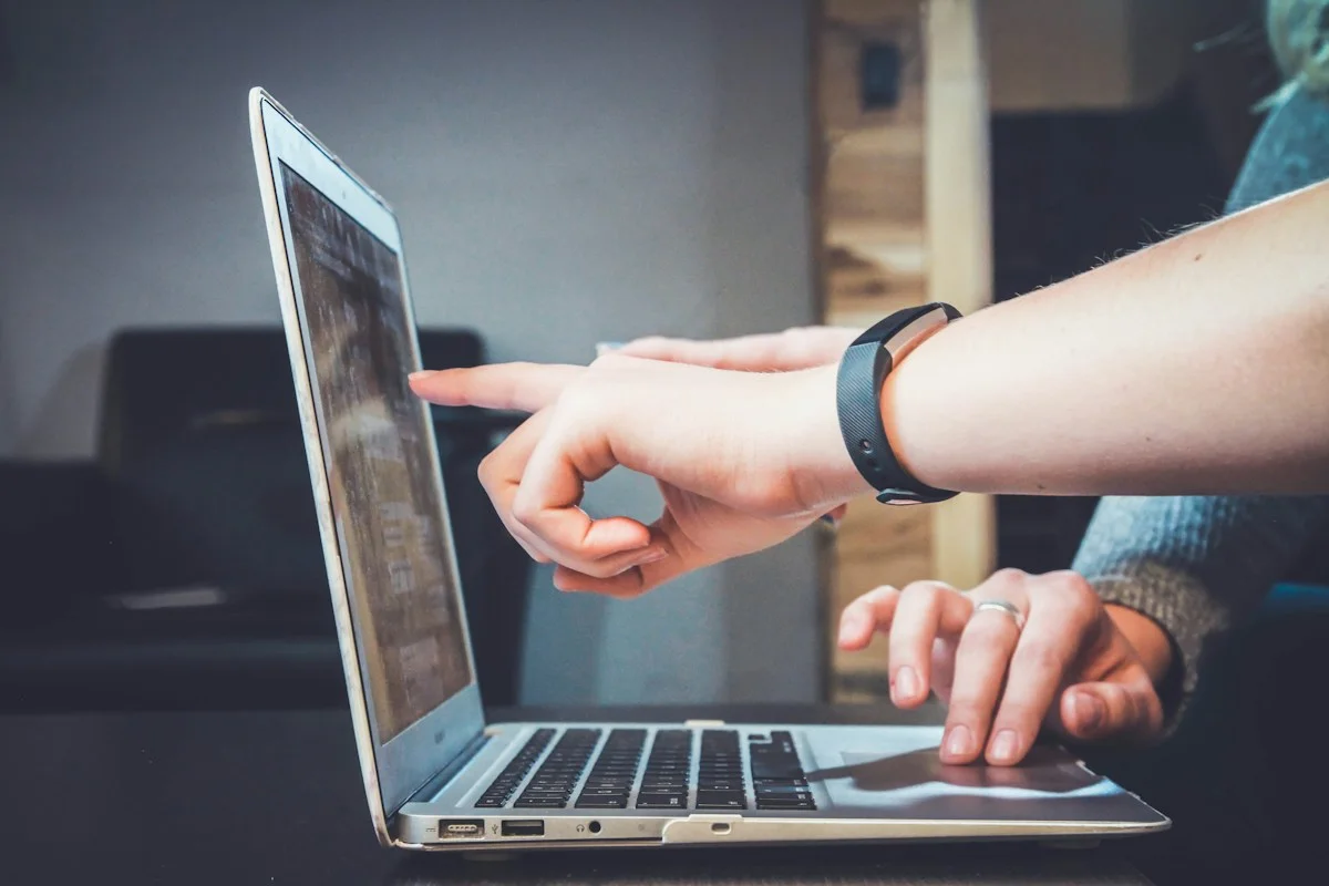 Two people discussing a laptop screen